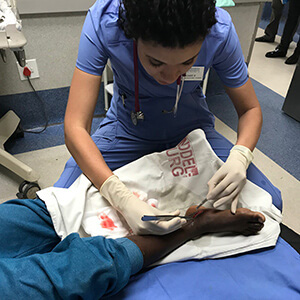 A CUW physician assistant student sutures in South Africa.