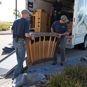 Maintenance workers haul the parts of the practice organ off the U-Haul on the Mequon campus. 