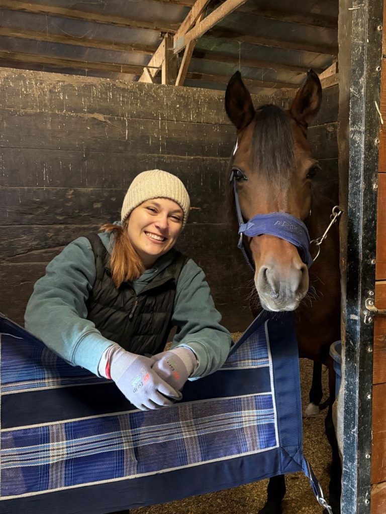 girl in barn next to horse