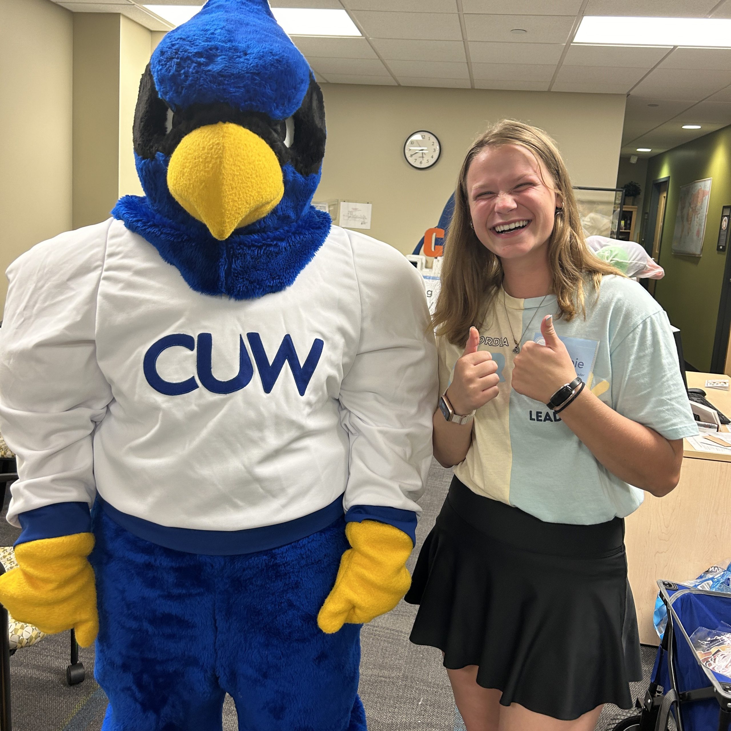 girl with blonde hair next to falcon mascot