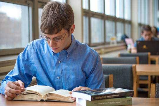 Adam Waggoner pours over academic texts in the library during finals week. After graduation, he will begin work on his master’s degree in philosophy.