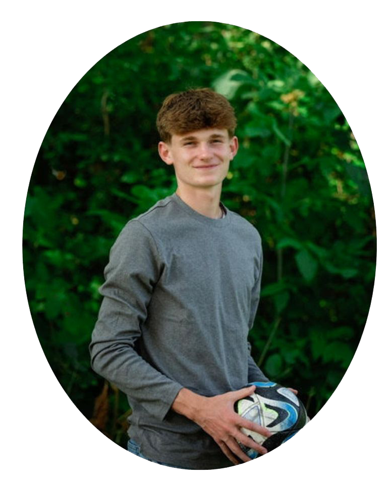 Waist shot of a boy holding a soccer ball. 