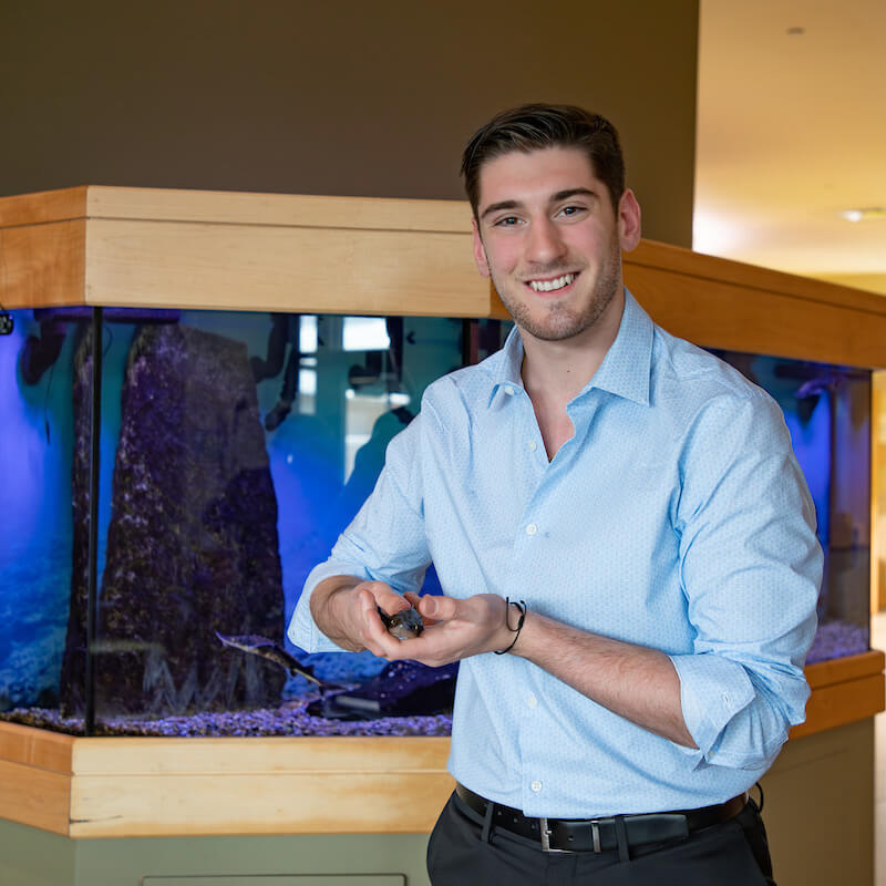 Alex Alexiades, an environmental science major, holds a lake sturgeon.
