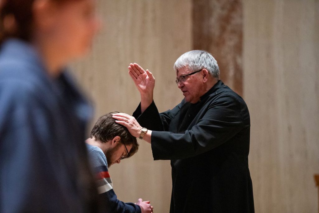 pastor praying over man