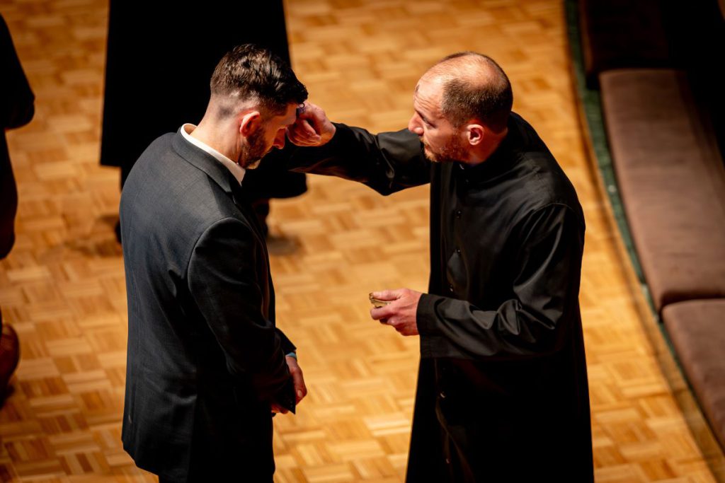 pastor putting ashes on man