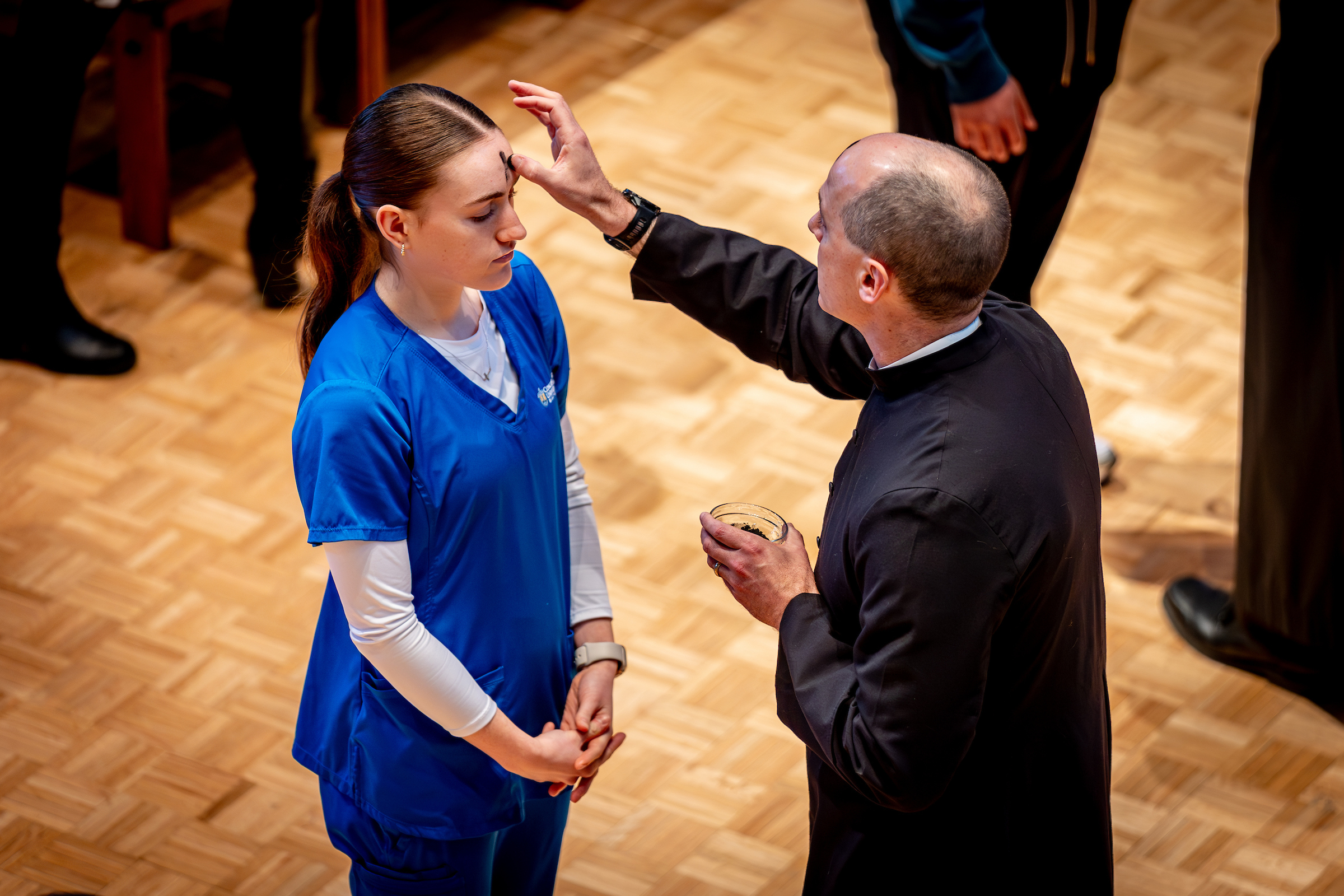 woman in scrubs with pastor