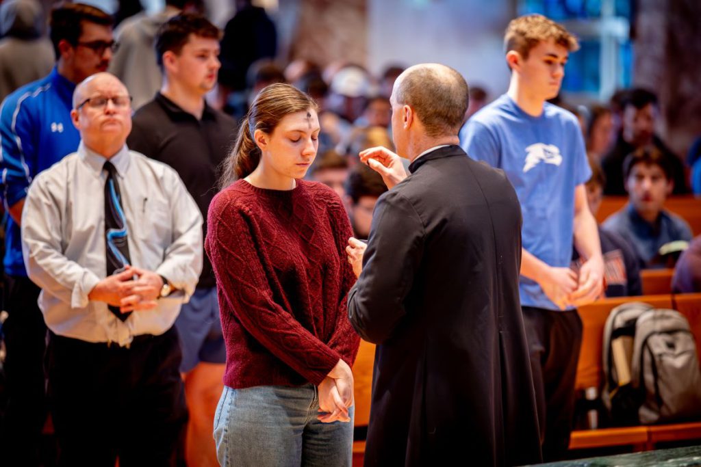woman getting a cross on her forehead with ashes