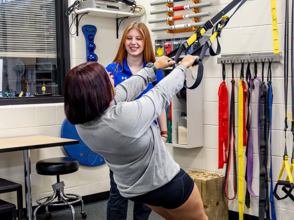 Brooke Trendel leads a patient through athletic training exercises.