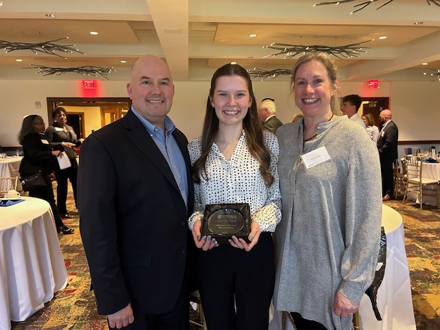 girl with award and parents