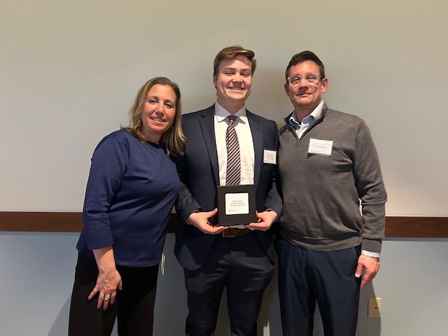 man with award and parents