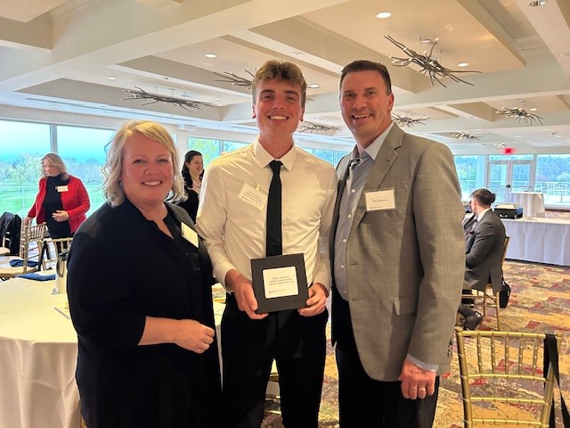 man with award and parents