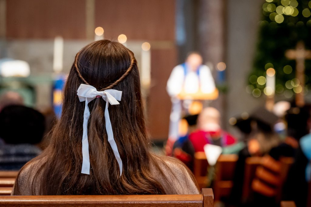 student listening to pastor view of back of her hair