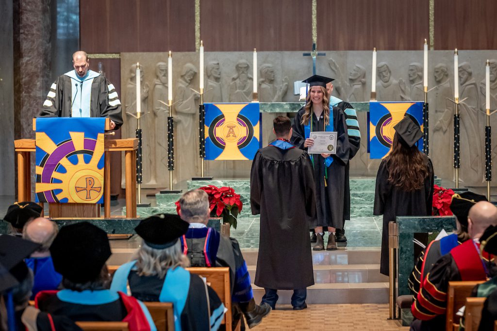 woman receiving degree in chapel