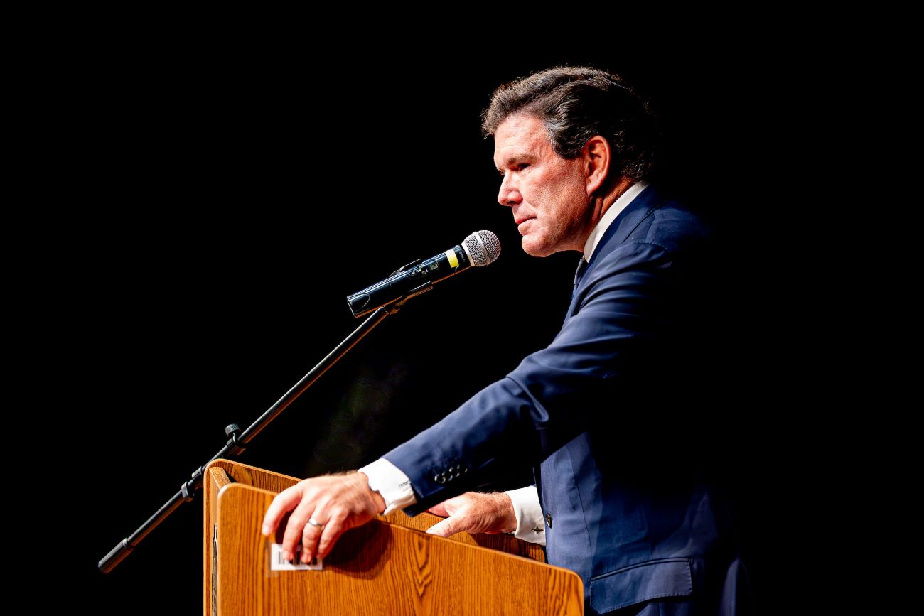 man at podium with blue jacket