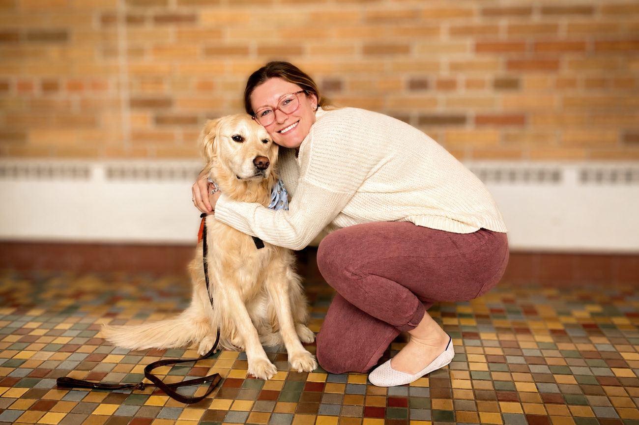 young woman with burgundy pants and golden retriever dog