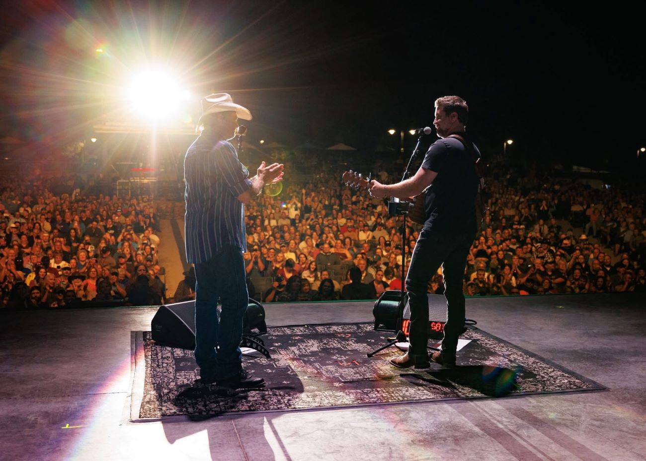 Musicians on stage with fans in background