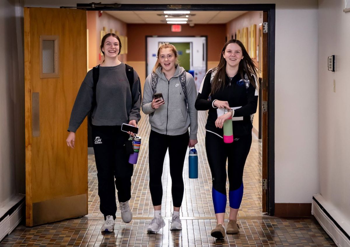students walking down hall with phones