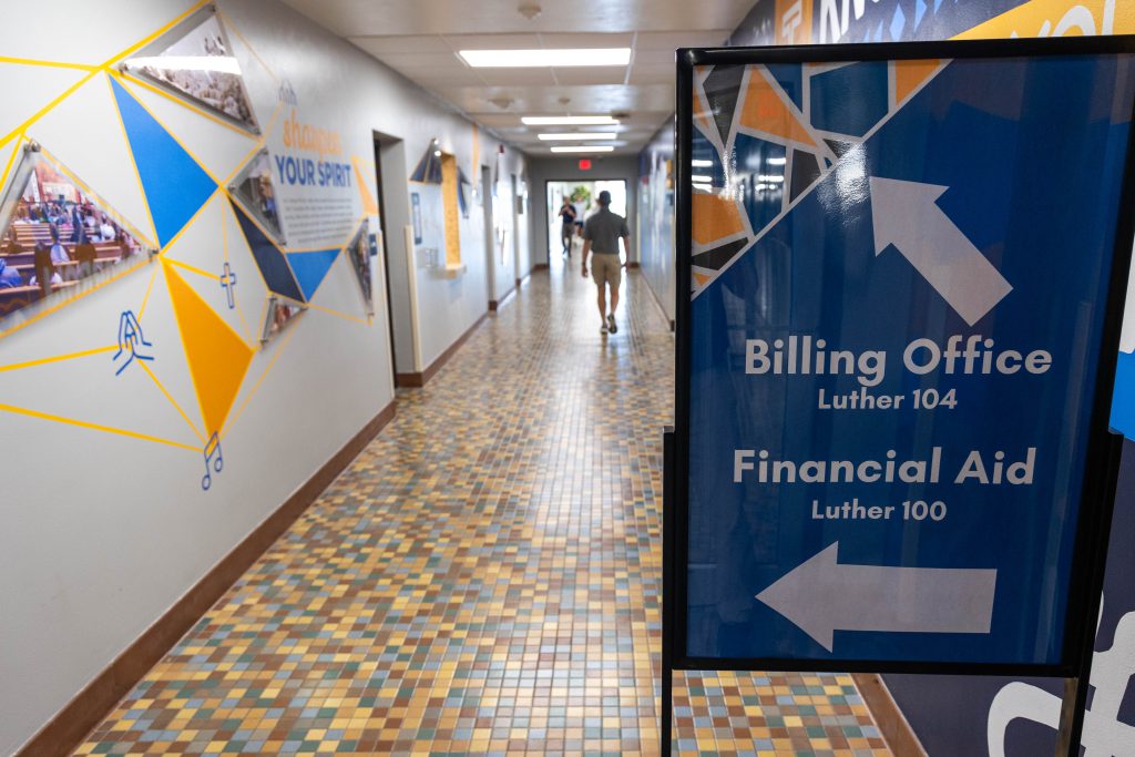 blue sign with arrows and a hallway