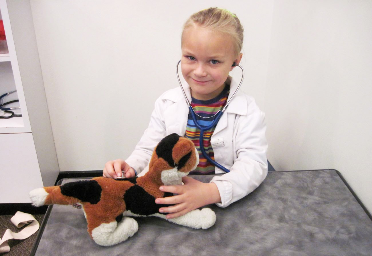 a blonde-haired little girl with a stuffed cat