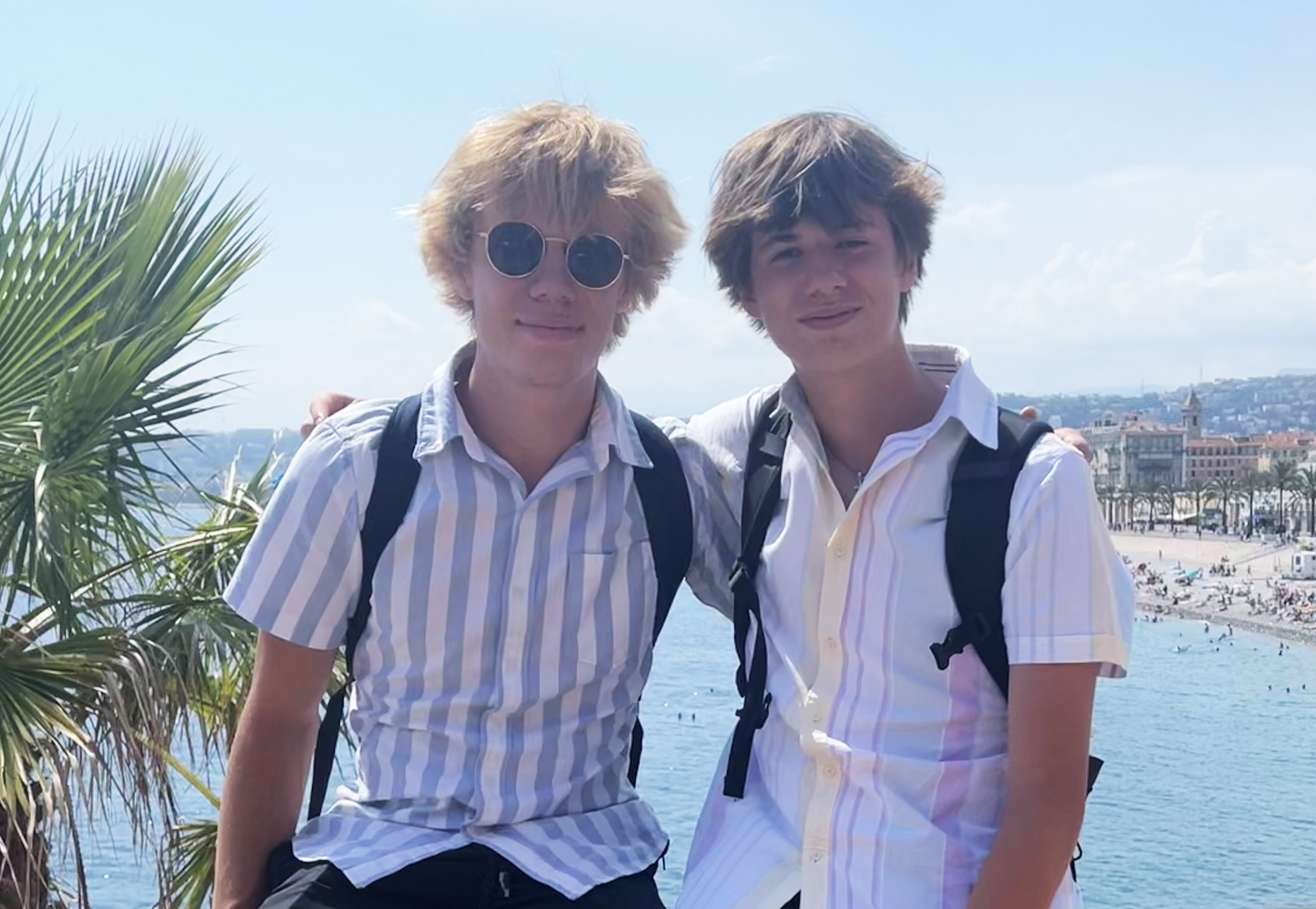 two young men posing in front of an ocean