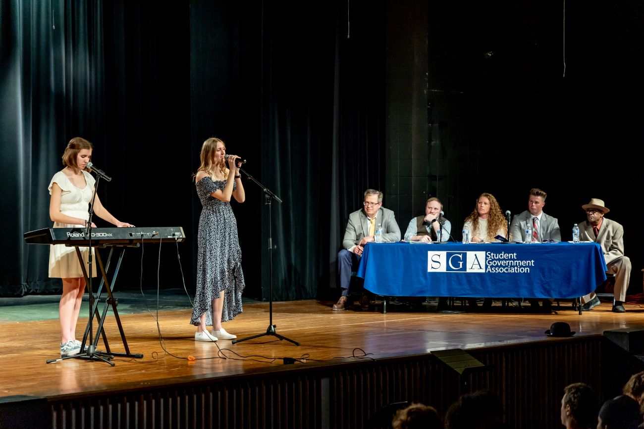 two girls performing on stage with judges in background