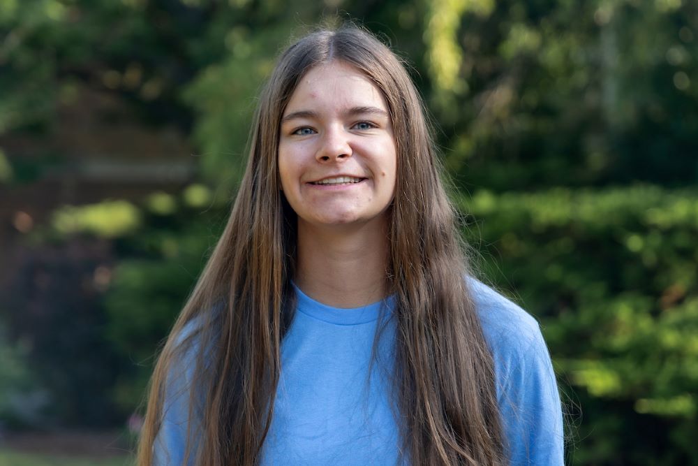 girl with long brown hair and blue shirt