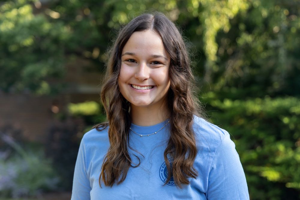 girl with curly brown hair and blue shirt