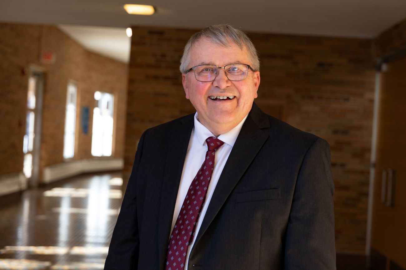 man in suit with glasses outside chapel