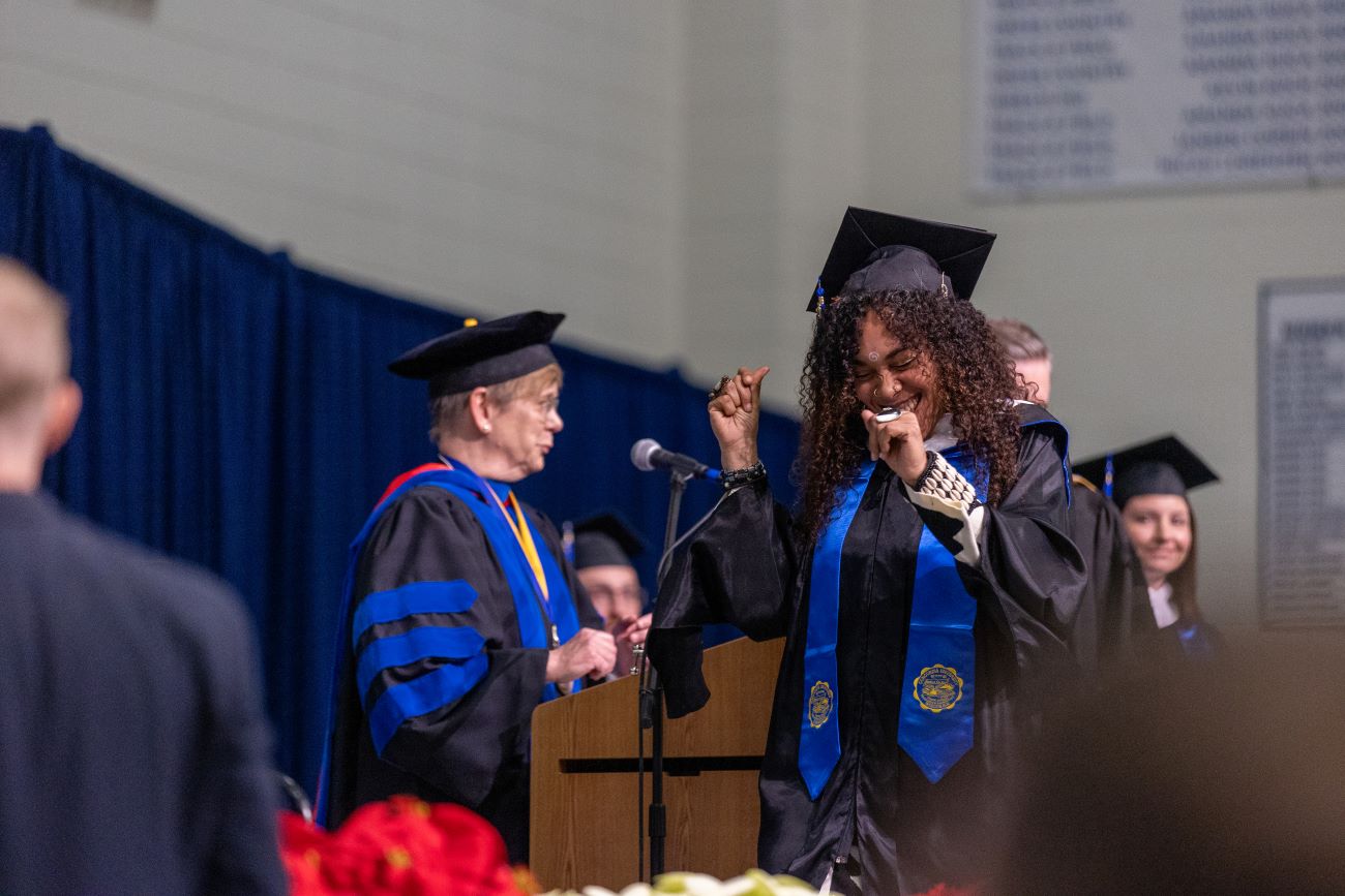 woman graduating and snapping her fingers