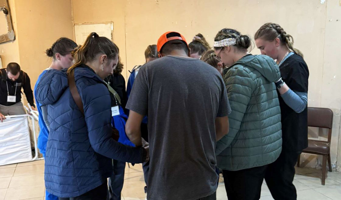 students huddled praying