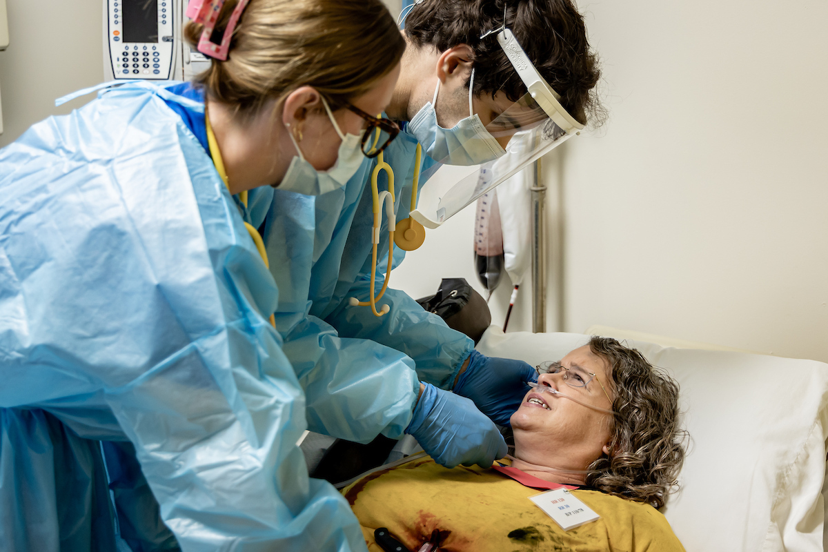 Two students working on a "wounded" patient in a disaster simulation
