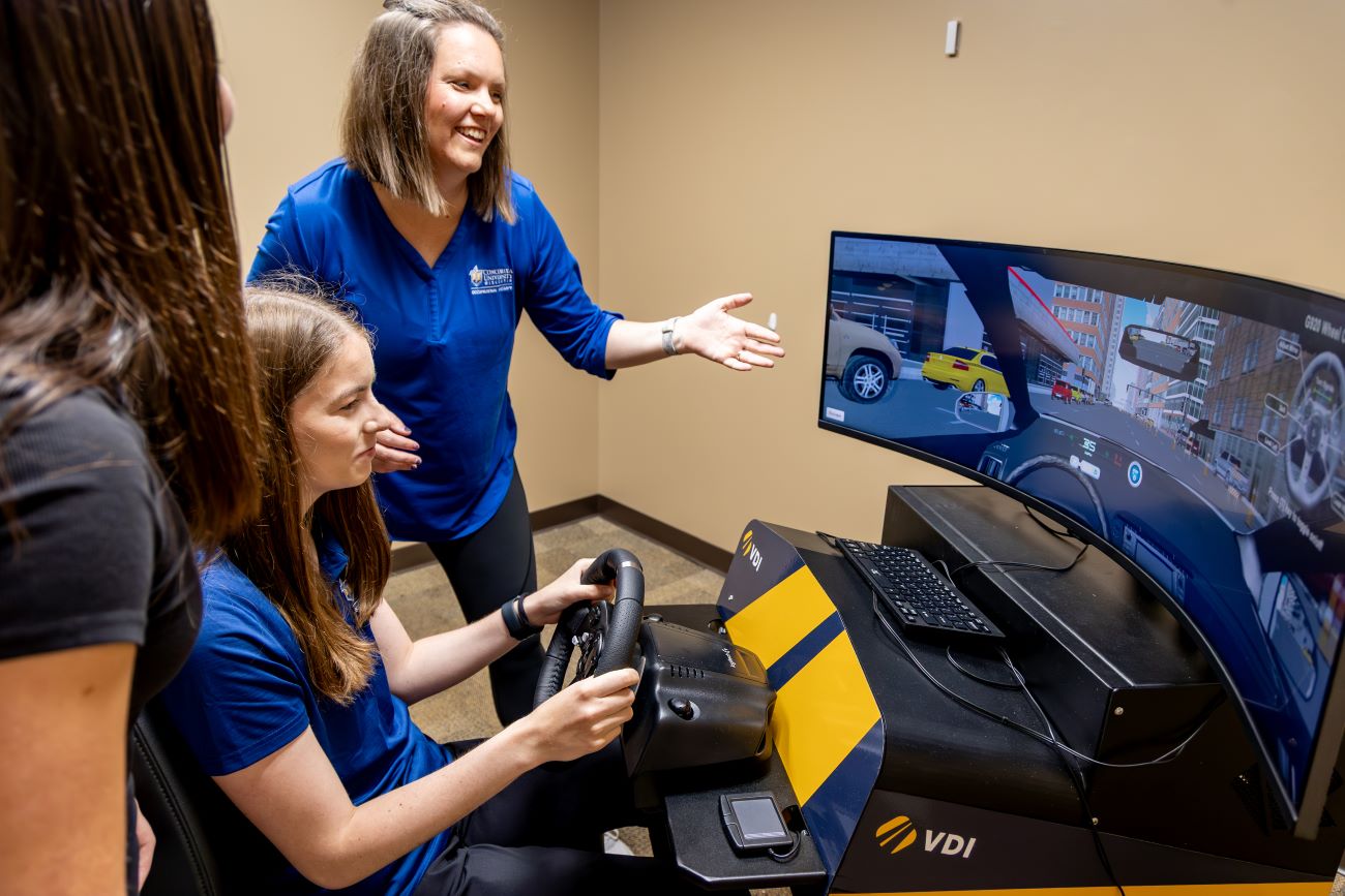teacher instructing students on driving sim