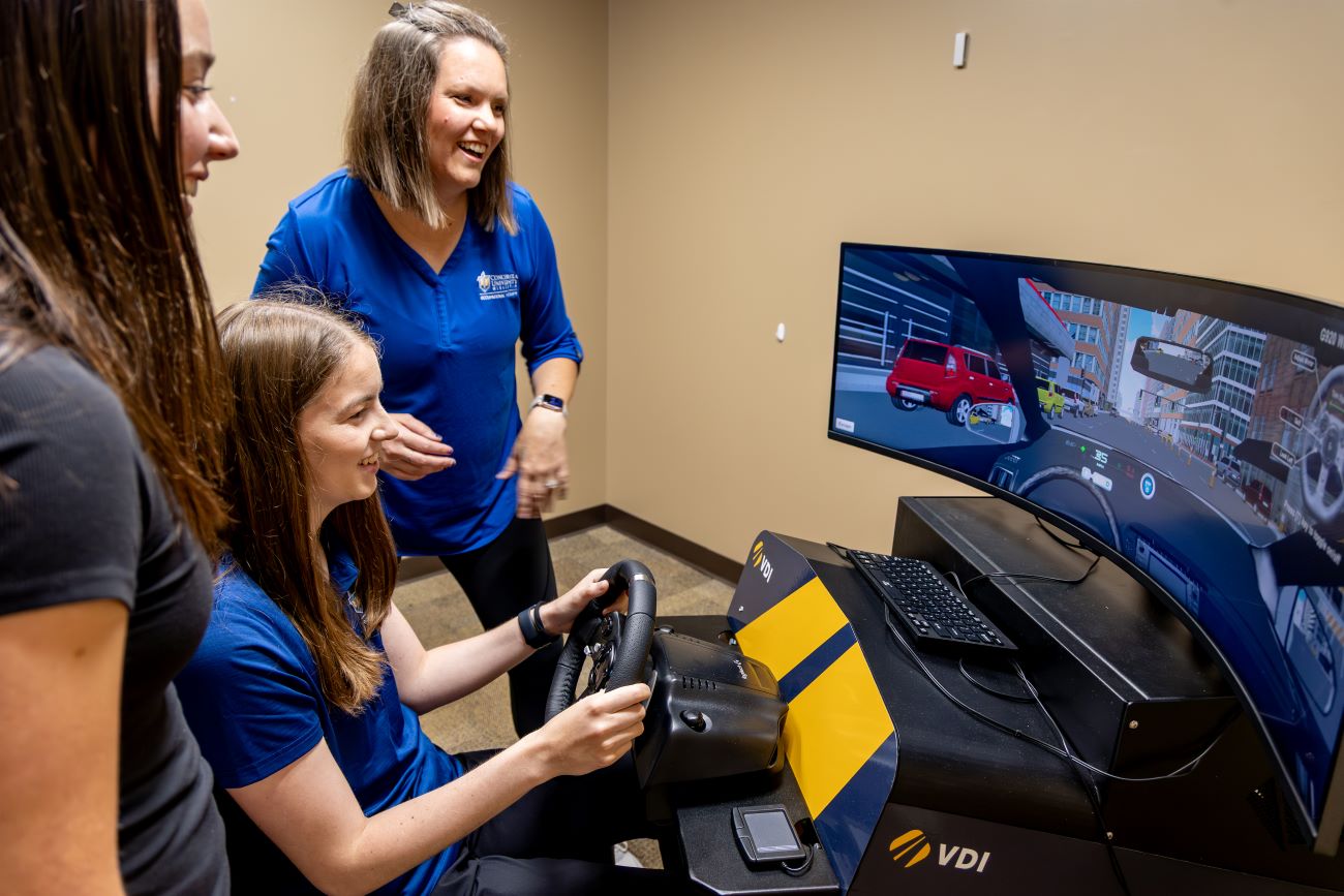 teacher instructing students on driving sim