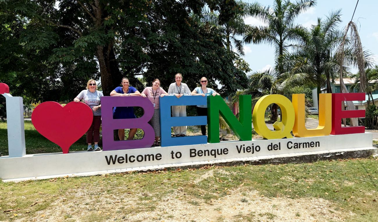 students posing by bring bright letters