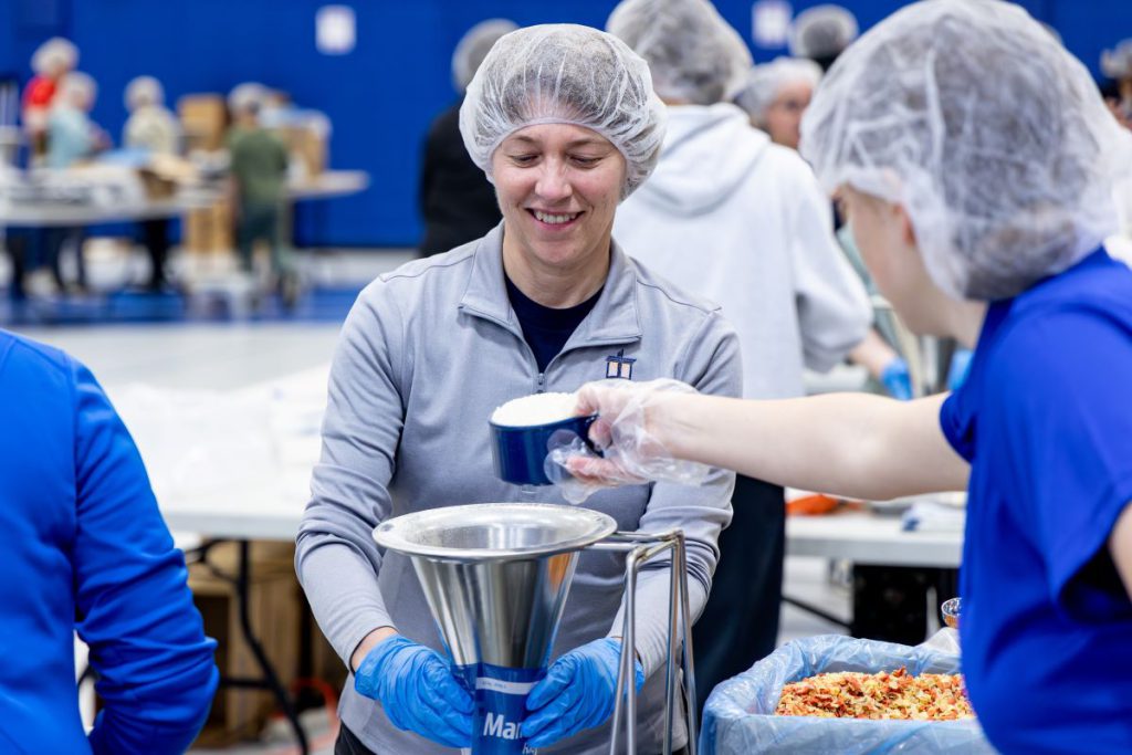 woman measuring food and putting into funnel