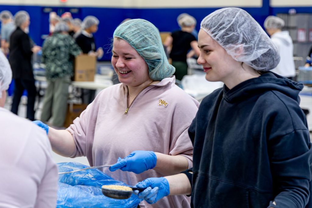 women smiling and packing meals
