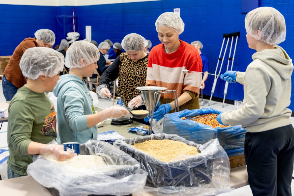 mom and kids packing meals