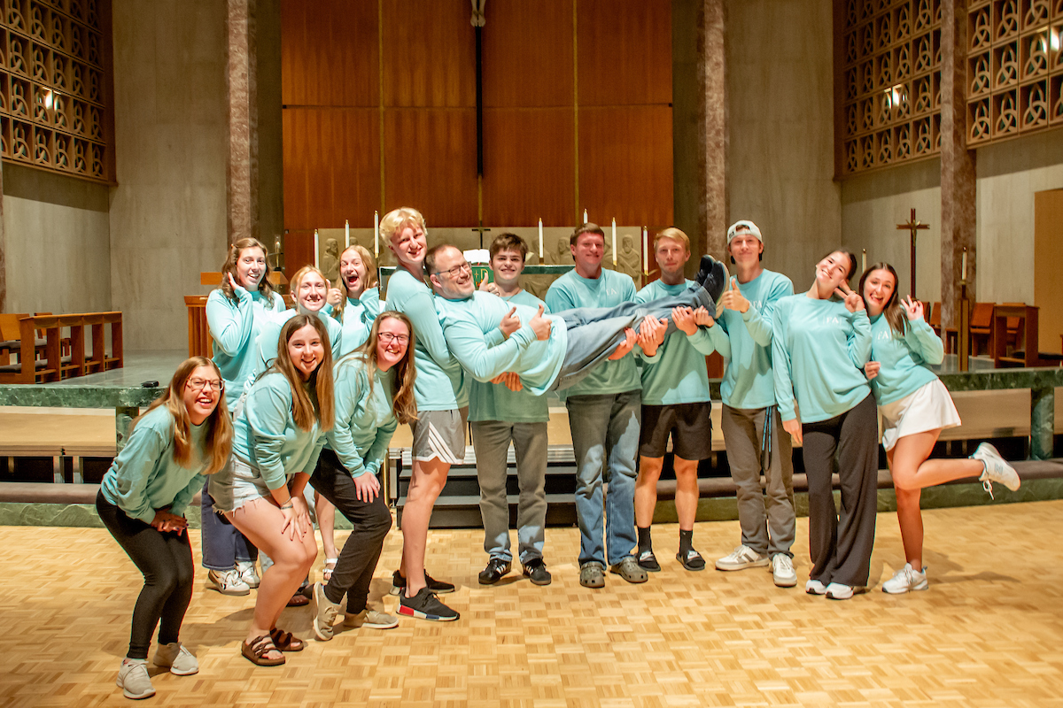 group of students in chapel with pastor