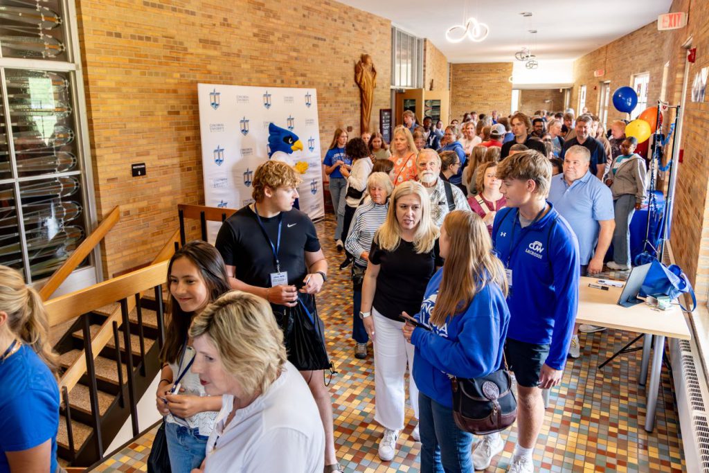 People walking through hall by Chapel
