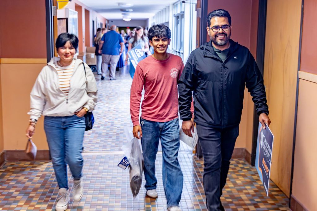 student with parents walking down hall