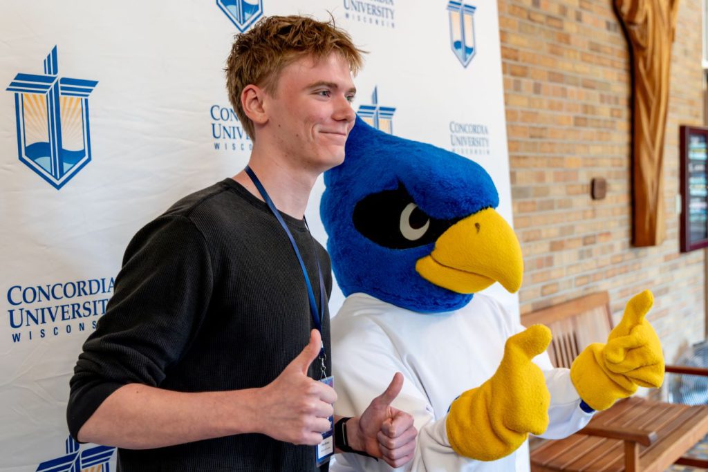 guy posing with Falcon mascot