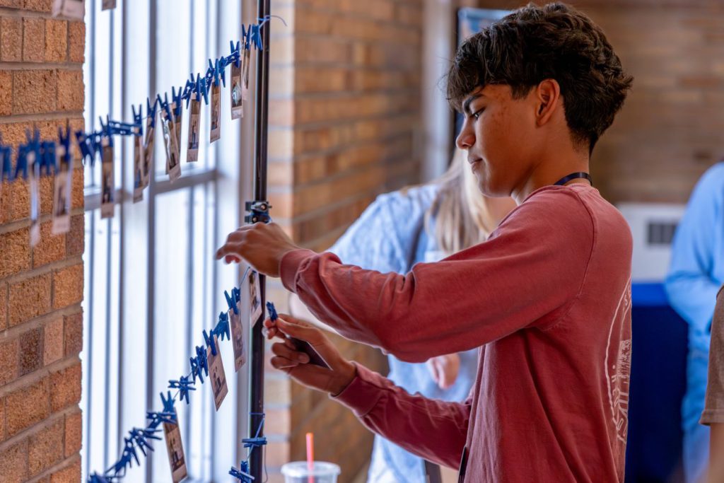 kid hanging photo up