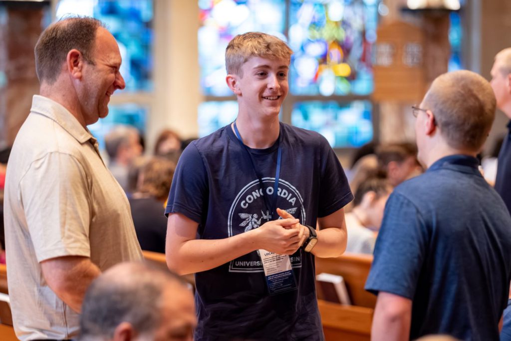 student talking to faculty in chapel