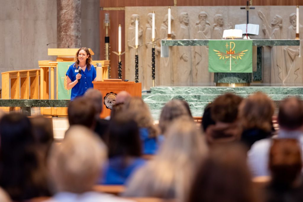 host speaking in front of chapel