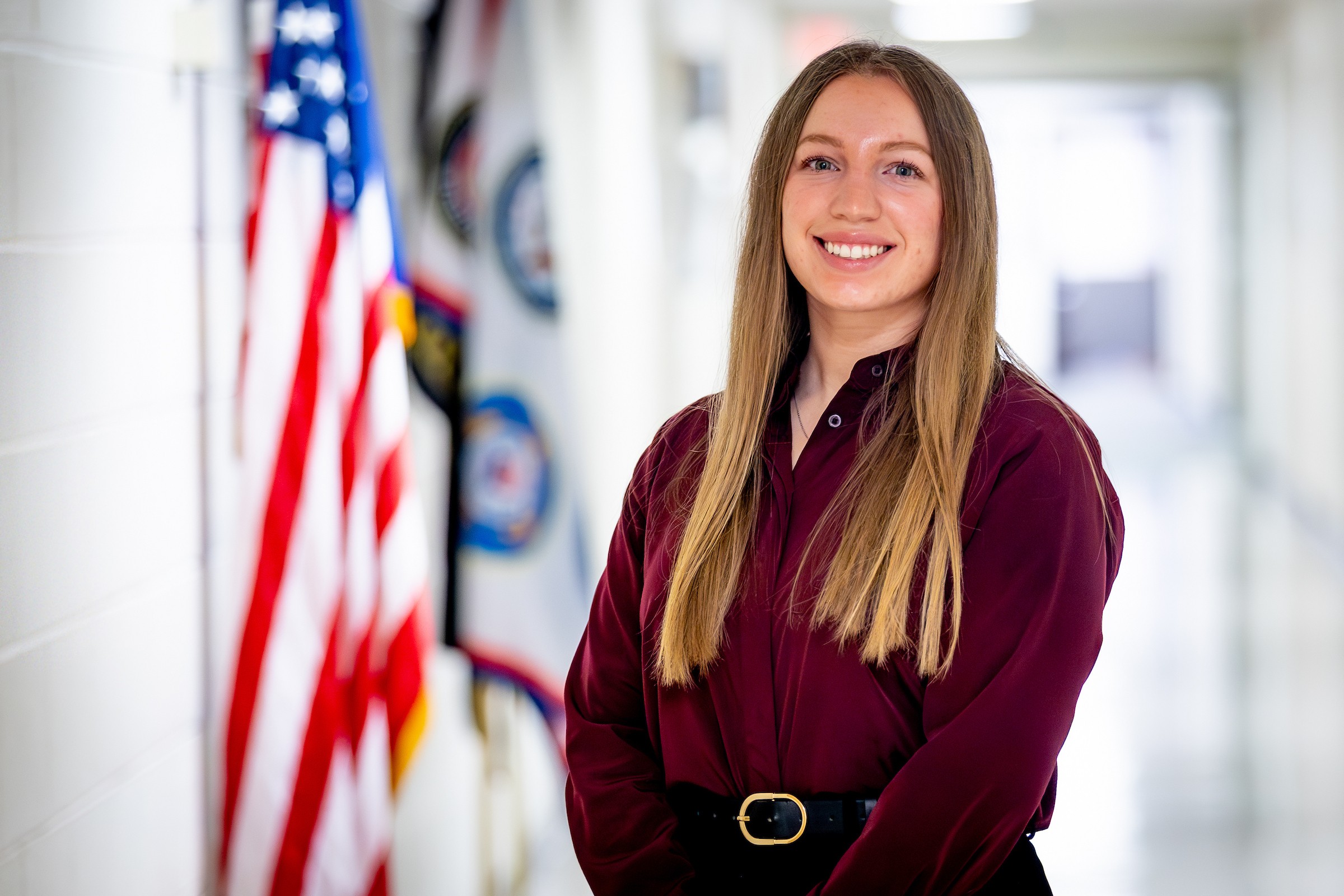 Gracie Wilson standing next to a flag