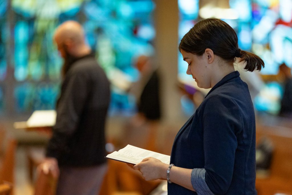 girl reading bible in chapel