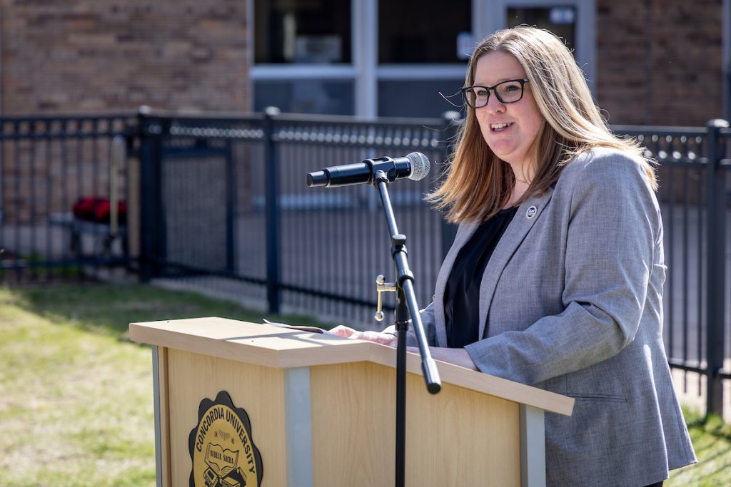 Amy Leppla speaks in front of a podium