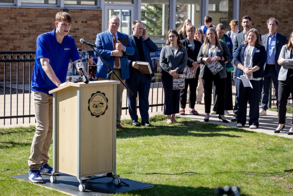 nursing student Luke Eggemeyer speaks from a podium