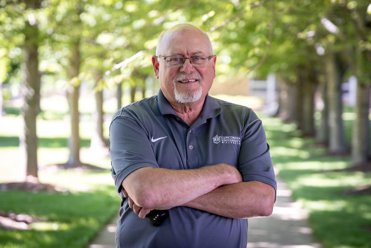 man with glasses and arms crossed with gray shirt on