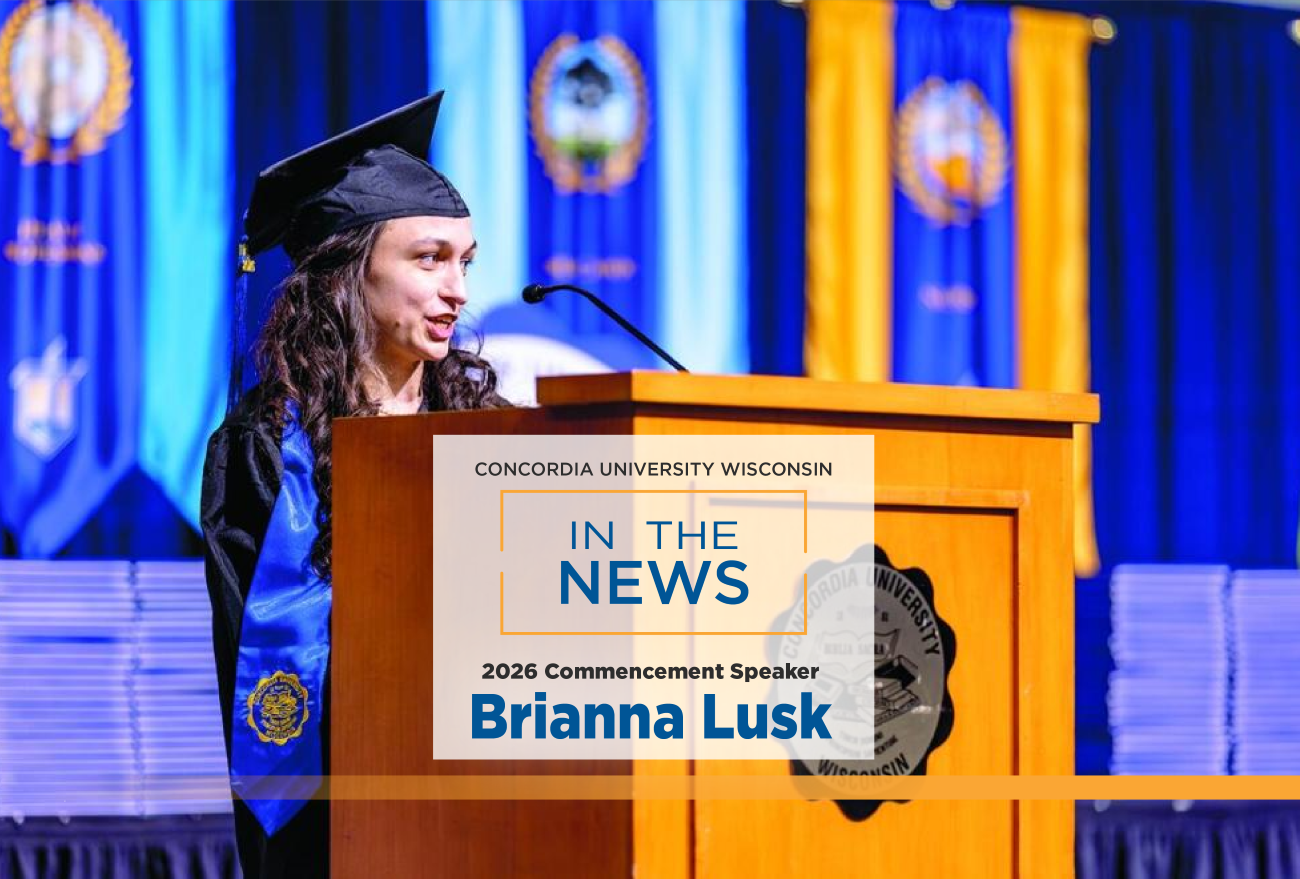 Brianna Lusk standing in front of a podium dressed in graduation garb with the words 